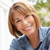 Woman smiling following dental implant treatment